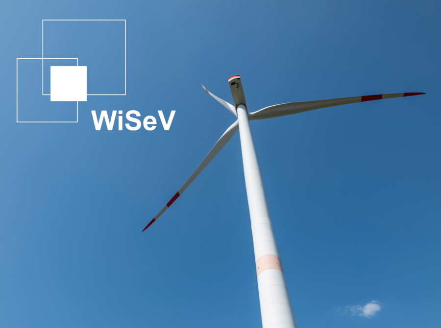 Aufnahme eines Windrades von unten vor blauem Himmel