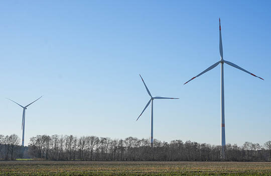 Drei Windräder auf einer Wiese